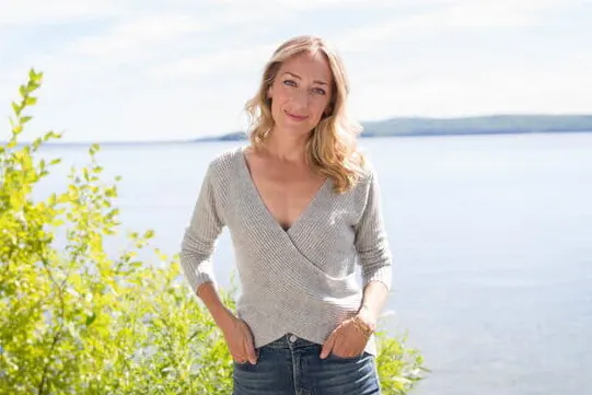 kris carr parada em frente a um lago